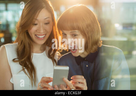 Imprenditrici utilizzando il cellulare in ufficio Foto Stock