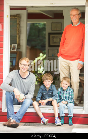 Fratelli sorridente con il padre e il nonno Foto Stock