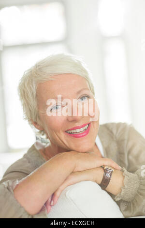 I vecchi donna sorridente sul divano Foto Stock