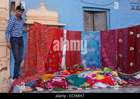 L'uomo vendere sari di tessuti in città blu, Jodphur, Rajasthan, India Foto Stock