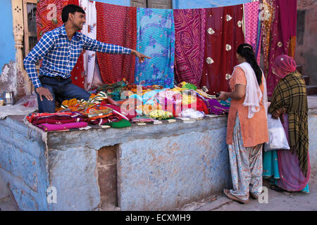 L'uomo vendere sari di tessuti in città blu, Jodphur, Rajasthan, India Foto Stock