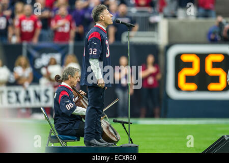 Houston, Texas, Stati Uniti d'America. Xxi Dec, 2014. Lyle Lovett esegue l inno nazionale prima di una partita di NFL tra Houston Texans e Baltimore Ravens presso NRG Stadium di Houston, TX su Dicembre 21st, 2014. I Texans hanno vinto il gioco 25-13. Credito: Trask Smith/ZUMA filo/Alamy Live News Foto Stock