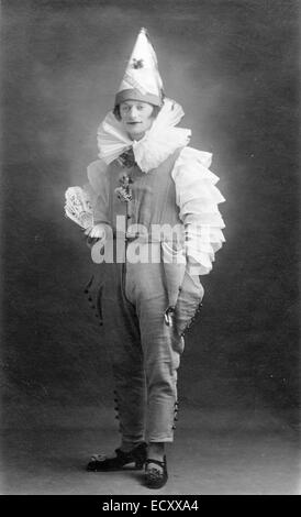 Circa 1920 ritratto in studio bianco e nero di Cyril Fairman, band leader. Giovane uomo negli anni venti, indossando abiti clown, guardando spettatore. Foto Stock