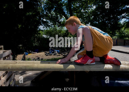 Ragazzo gioca in avversione al rischio parco giochi chiamato terra su Plas Madoc station wagon, Ruabon, Wrexham, Galles. Foto Stock