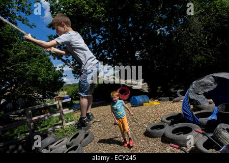 Ragazzi giocare in avversione al rischio parco giochi chiamato terra su Plas Madoc station wagon, Ruabon, Wrexham, Galles. Foto Stock