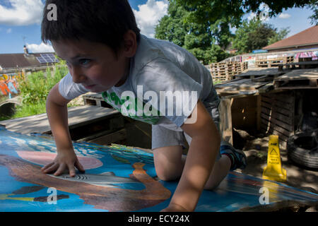 Ragazzo gioca in avversione al rischio parco giochi chiamato terra su Plas Madoc station wagon, Ruabon, Wrexham, Galles. Foto Stock