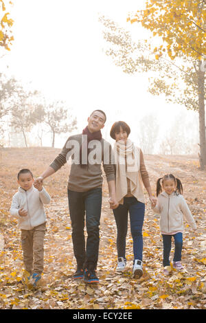 Famiglia con due bambini passeggiate al parco Foto Stock