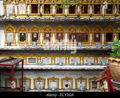 Una parete di cremazione urne cinerarie in Thai piccolo tempio buddista. Bangkok. Della Thailandia Foto Stock