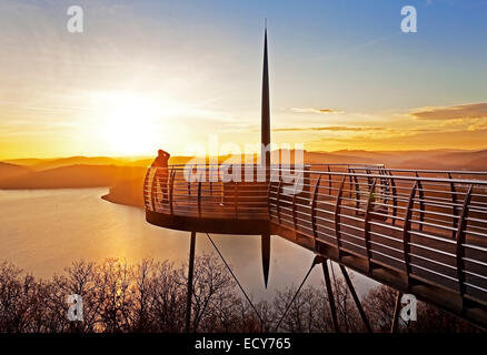 Piattaforma di Osservazione Biggeblick con una persona al tramonto, Biggesee reservoir, Attendorn, Sauerland, Nord Reno-Westfalia, Germania Foto Stock