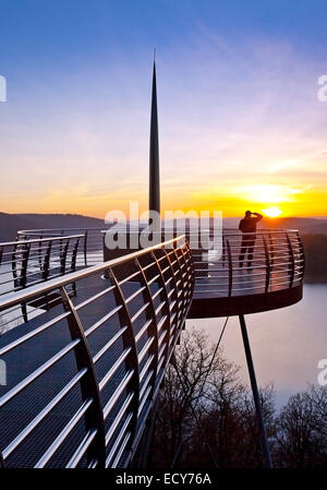 Piattaforma di Osservazione Biggeblick con una persona al tramonto, Biggesee reservoir, Attendorn, Sauerland, Nord Reno-Westfalia, Germania Foto Stock