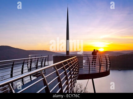 Piattaforma di Osservazione Biggeblick con una persona al tramonto, Biggesee reservoir, Attendorn, Sauerland, Nord Reno-Westfalia, Germania Foto Stock