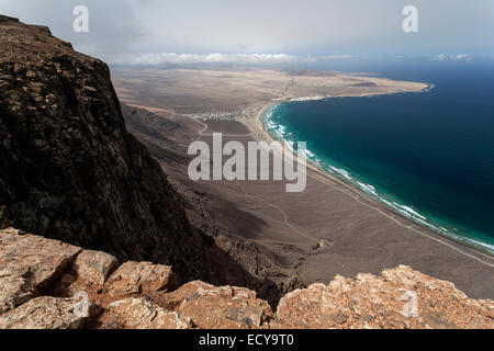 Vista dal Mirador del Bosquecillo, Risco de Famara, sulla spiaggia di Famara o Playa de Famara con la Calaeta e Famara resort Foto Stock