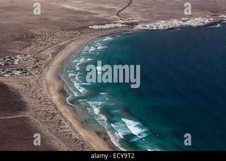 Vista dal Mirador del Bosquecillo, Risco de Famara, sulla spiaggia di Famara o Playa de Famara con la Calaeta e Famara resort Foto Stock