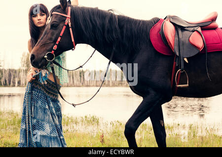 La donna caucasica passeggiate a cavallo all'aperto Foto Stock