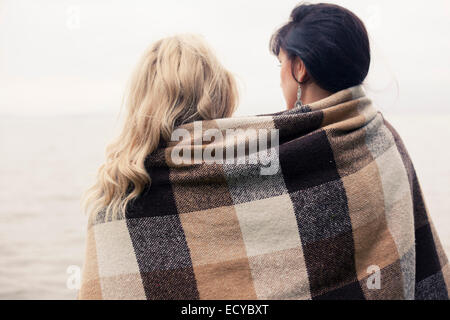 Donne caucasici avvolto in una coperta all'aperto Foto Stock