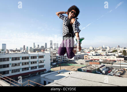 African American uomo salti di gioia sul tetto urbano Foto Stock