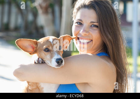 La donna caucasica holding cane all'aperto Foto Stock