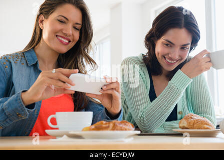 Donne ispaniche tenendo cellulare fotografia di prima colazione Foto Stock