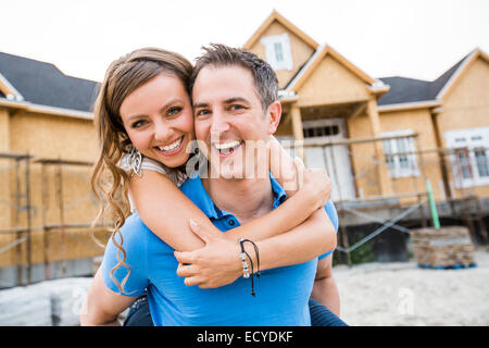 Caucasian giovane costeggiata vicino casa in costruzione Foto Stock