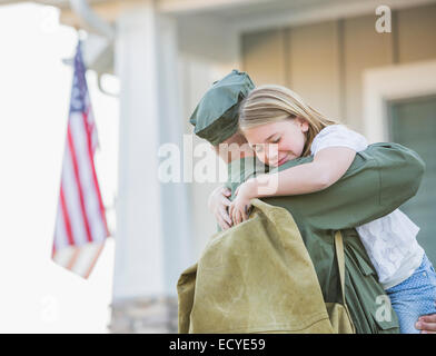 Tornando soldato caucasica abbracciando la figlia Foto Stock