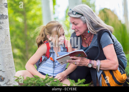 Nonna caucasica e nipote leggendo la guida durante le escursioni Foto Stock