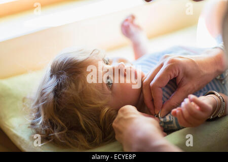 Madre medicazione baby boy sulla modifica tabella Foto Stock