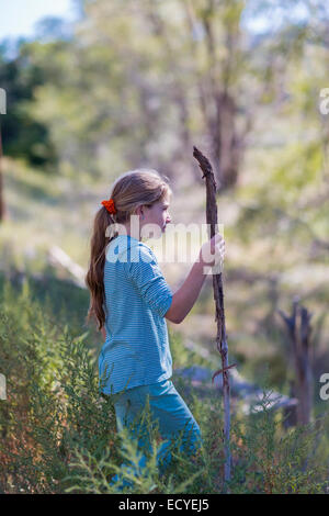 Caucasian ragazza camminare nelle zone rurali del campo erboso Foto Stock