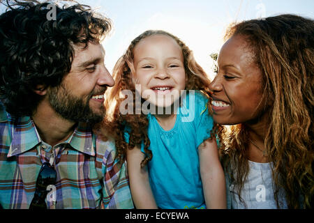 I genitori e la figlia sorridente insieme all'aperto Foto Stock