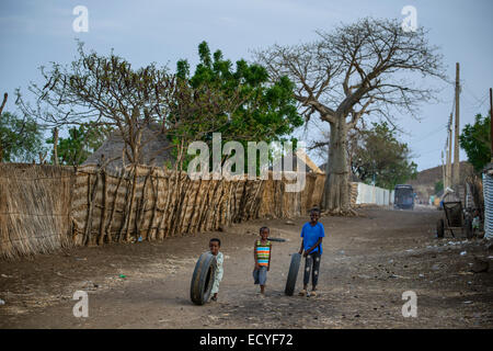 I bambini a giocare con vecchi pneumatici vicino al Galabat, Sudan Foto Stock