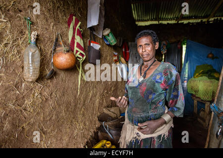 Una madre alla sua casa tradizionale, Etiopia Foto Stock