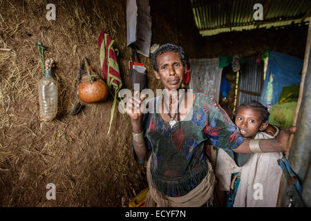 Una madre alla sua casa tradizionale, Etiopia Foto Stock