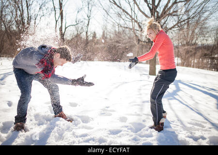 Coppia caucasica avente lotta con le palle di neve Foto Stock