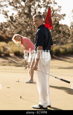 Coppia caucasica giocando a golf sul corso Foto Stock