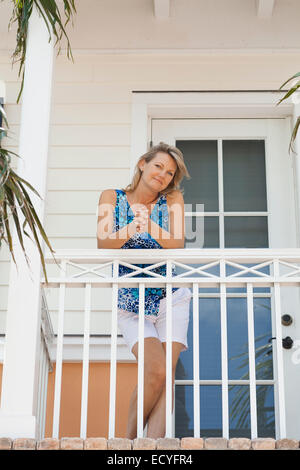 Caucasian donna in piedi sul balcone Foto Stock