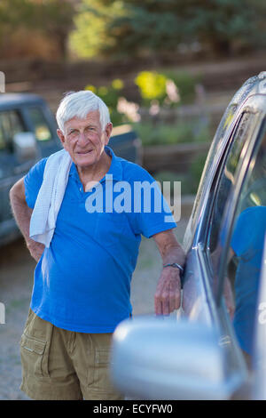 Senior uomo caucasico appoggiata contro l'auto Foto Stock