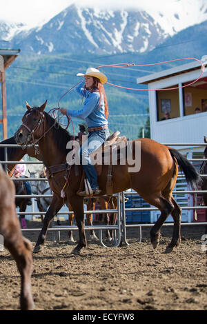 Caucasian cowgirl di equitazione in rodeo sul ranch Foto Stock