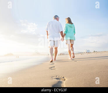 Coppia caucasica di lasciare impronte sulla spiaggia Foto Stock