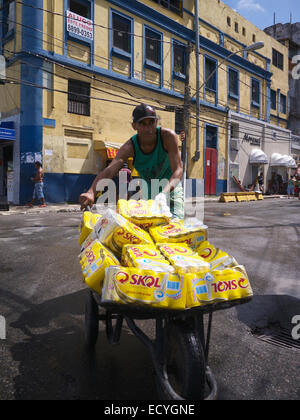 SALVADOR, Brasile - 9 febbraio 2013: Vendor trasporta carriola piena Skol birra di marca verso festeggiamenti carnevaleschi a barra. Foto Stock