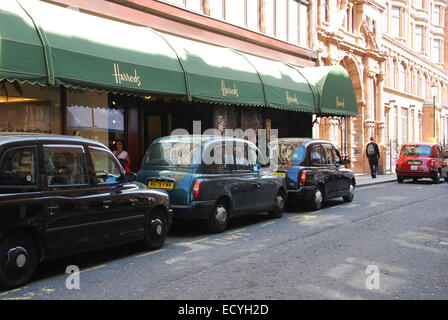 I taxi in attesa al di fuori dei magazzini Harrods, Knightsbridge London REGNO UNITO Foto Stock