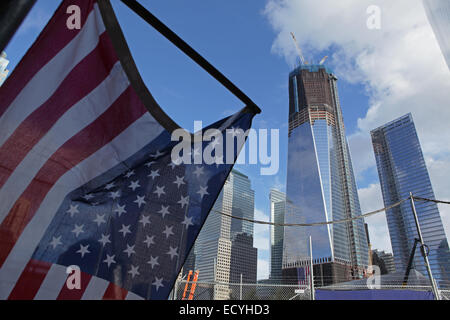 Una bandiera americana si blocca sul marciapiede sul Liberty Street di fronte di One World Trade Center a Ground Zero a New York Foto Stock