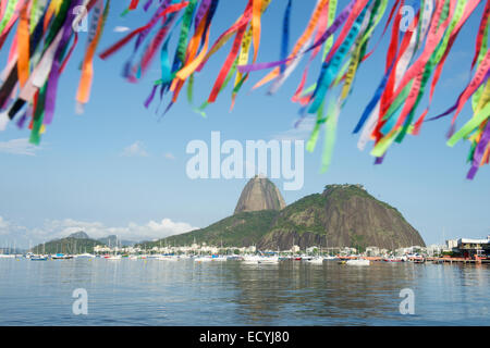 Brasiliano nastri desideri volare al di sopra vista panoramica di Sugarloaf Mountain e il Botafogo Bay Foto Stock