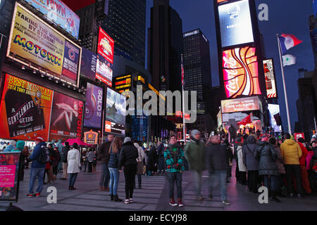 La folla e i cartelloni in Times Square a New York sera lunga esposizione sfocatura del movimento Foto Stock