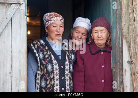 Tre donne del Kirghizistan in posa nella porta di casa di villaggio Sary-Tash / Sary Tash nell'Alay Valley, Provincia di SSL, Kirghizistan Foto Stock