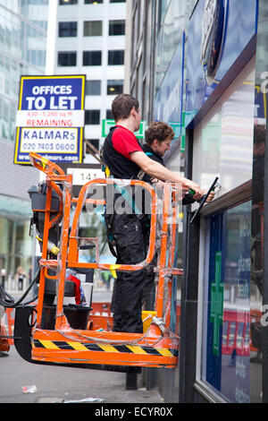 Londra - Ottobre 18th: Uomini non identificati la pulizia di un negozio di fronte a ottobre 18th, 2014 a Londra, Inghilterra, Regno Unito. Pulitori necessità di fol Foto Stock