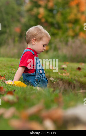 Profilo di un due-anno-vecchio ragazzo in tuta in jeans in autunno. Foto Stock