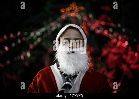 La striscia di Gaza. 22 dic 2014. Palestinese cristiano di famiglie nella Striscia di Gaza si illumina di albero di Natale Eid al di fuori della Chiesa Ortodossa di Gaza City. Credito: Ahmed Hjazy/Pacific Press/Alamy Live News Foto Stock