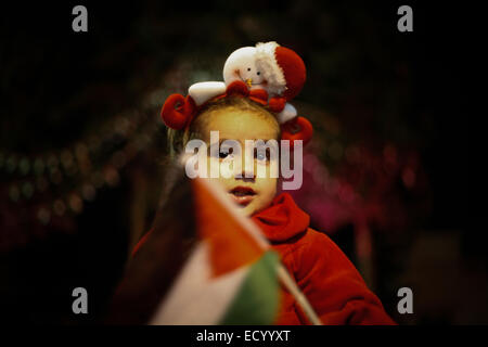 La striscia di Gaza. 22 dic 2014. Palestinese cristiano di famiglie nella Striscia di Gaza si illumina di albero di Natale Eid al di fuori della Chiesa Ortodossa di Gaza City. Credito: Ahmed Hjazy/Pacific Press/Alamy Live News Foto Stock