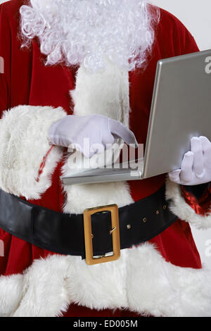 Babbo Natale utilizzando laptop su sfondo bianco Foto Stock