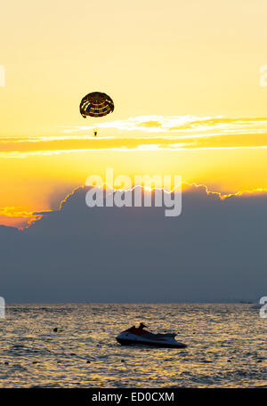 Il parasailing e jet ski al tramonto Foto Stock