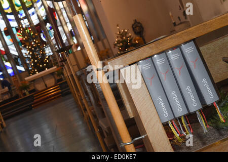 Munich-Neuaubing, Germania. 23 dic 2014. "Gotteslob' inno libri stand su un banco nella chiesa cattolica di san Konrad in Munich-Neuaubing, Germania, 23 dicembre 2014. I preparativi per le vacanze di Natale sono in pieno svolgimento presso la parrocchia. Foto: Felix Hoerhager/dpa - nessun filo SERVICE -/dpa/Alamy Live News Foto Stock